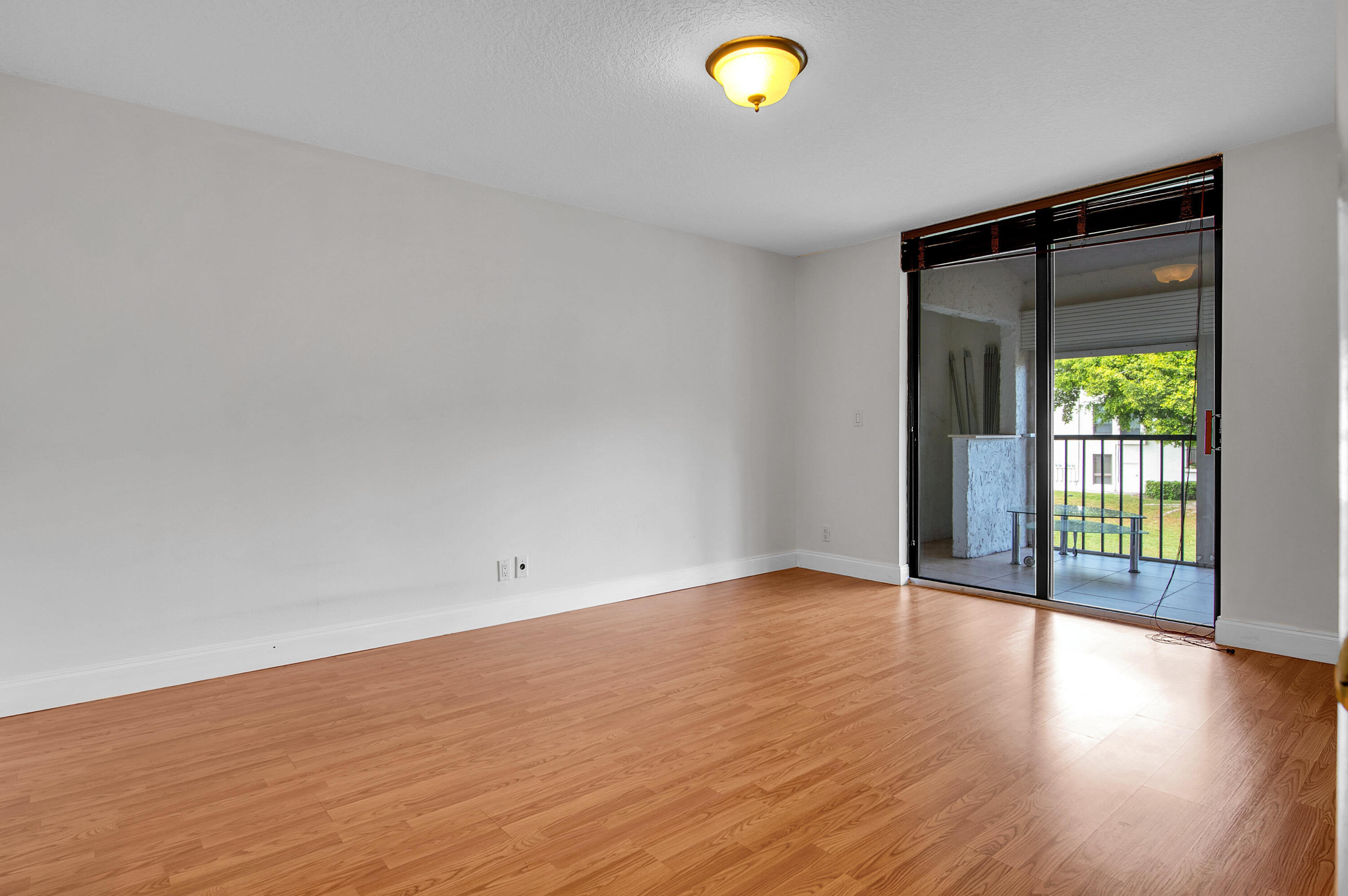 7888 La Mirada Drive Boca Raton, FL 33433 - Photo 39 of 61 a view of an empty room with wooden floor and a window