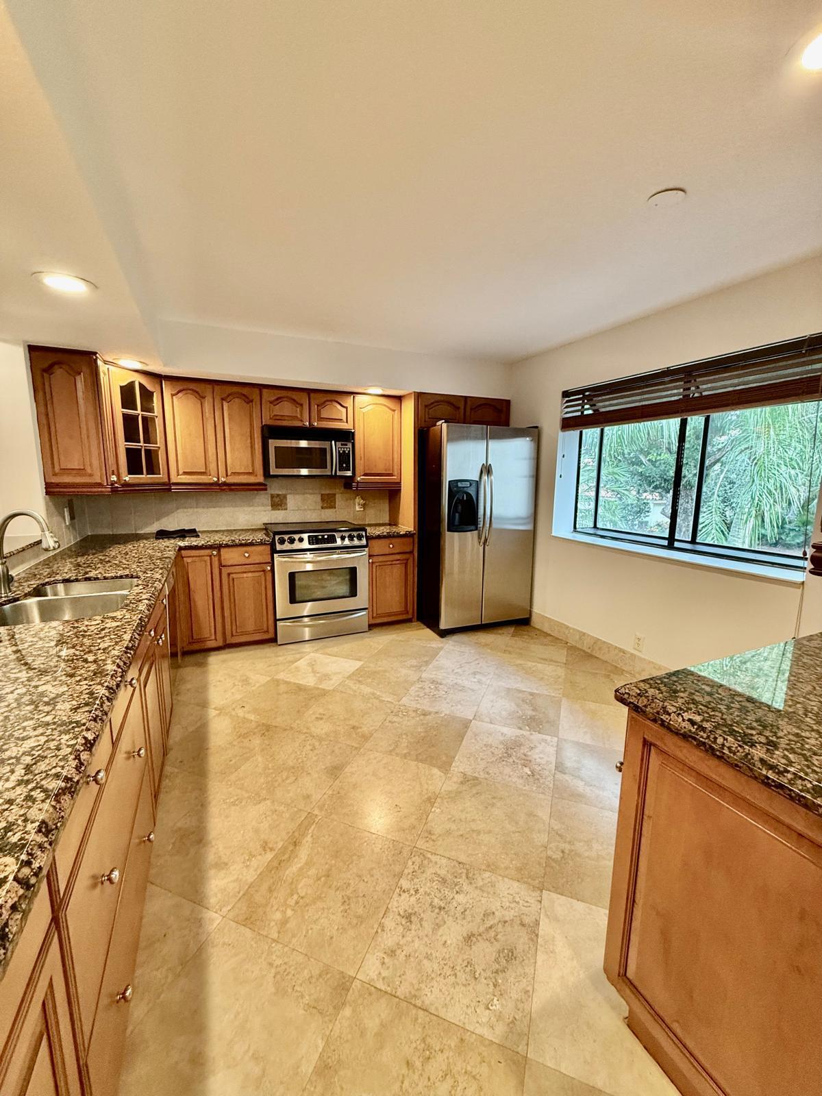 7888 La Mirada Drive Boca Raton, FL 33433 - Photo 5 of 29 a open kitchen with stainless steel appliances granite countertop a refrigerator stove top oven dining table and chairs