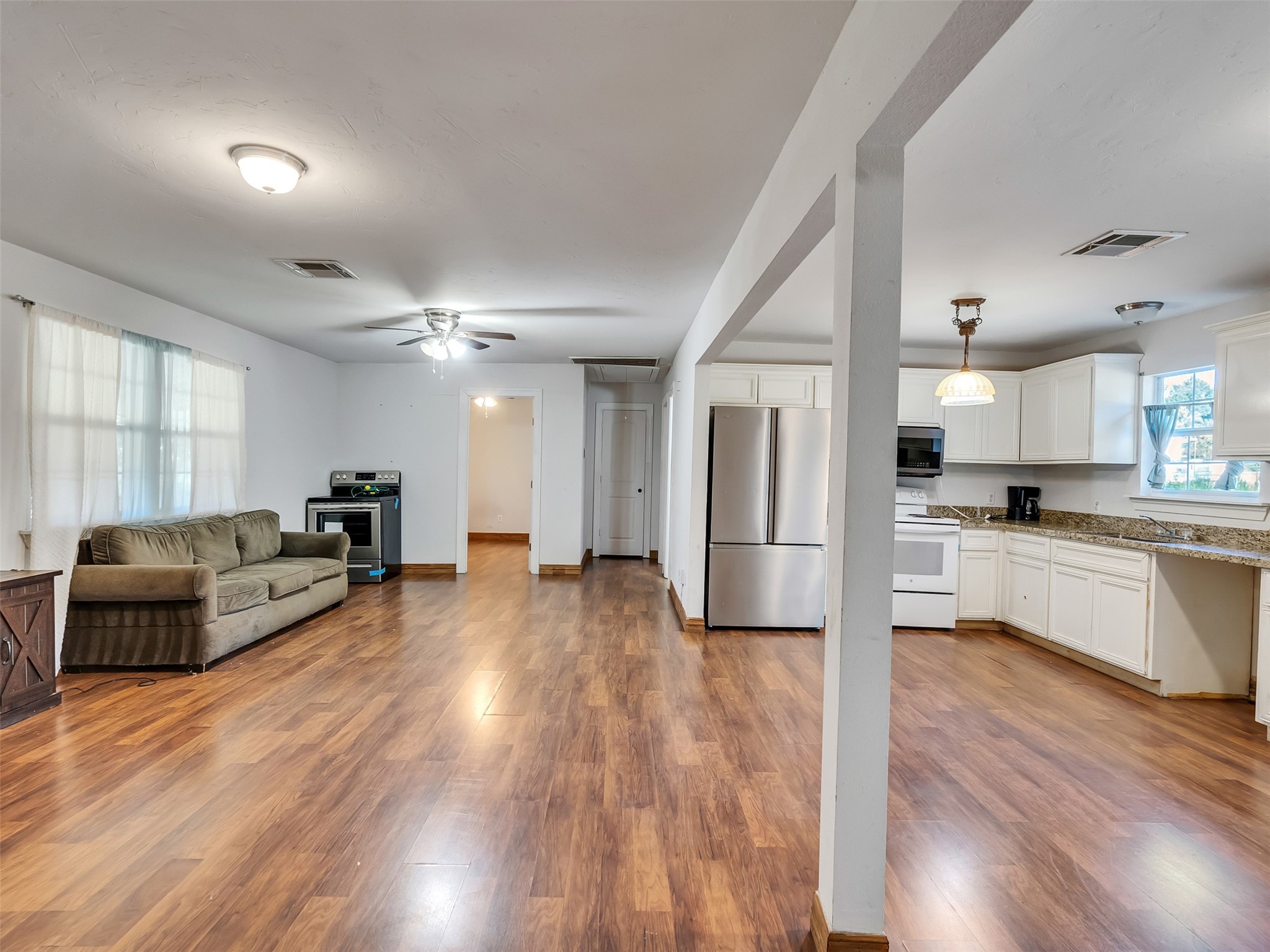 81 Hicks Cleveland, TX 77328 - Photo 10 of 24 a large living room with stainless steel appliances kitchen island granite countertop wooden floors and a view of living room