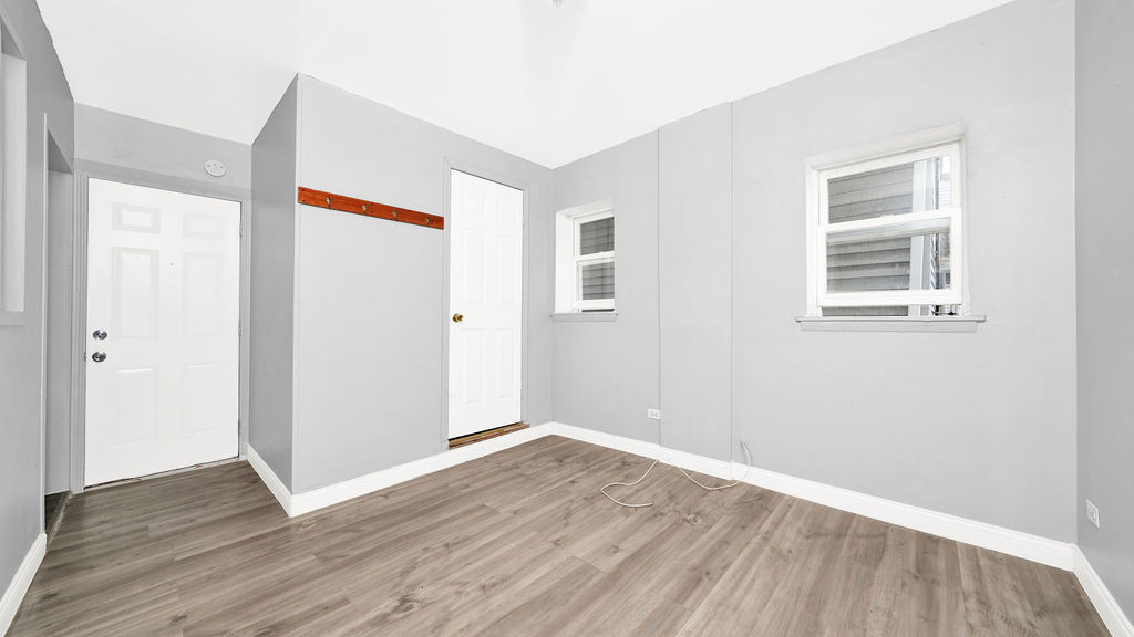 1831 West 21st Place, Unit 1R Chicago, IL 60608 - Photo 2 of 10 a view of an empty room with wooden floor and a window