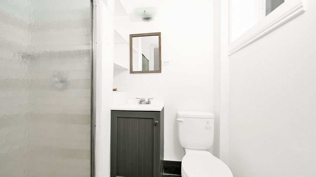 1831 West 21st Place, Unit 1R Chicago, IL 60608 - Photo 5 of 10 a bathroom with a toilet a sink and mirror