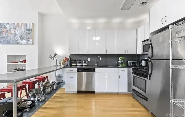 a kitchen with stainless steel appliances granite countertop a refrigerator and a stove top oven