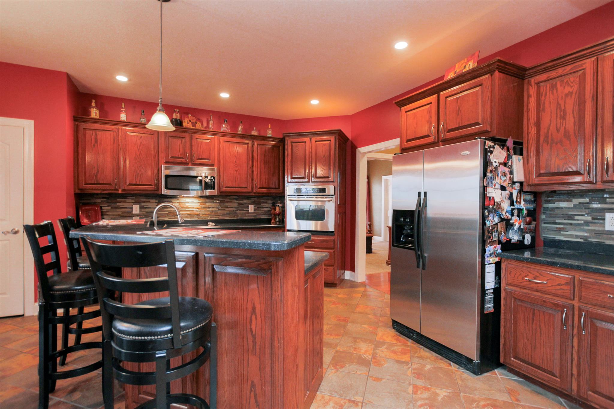 3463 Ott Wilson Road Springfield, TN 37172 - Photo 8 of 30 a kitchen with stainless steel appliances granite countertop a refrigerator a stove a sink a dining table and chairs with wooden floor