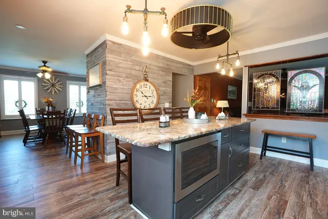 a kitchen with granite countertop a stove and a wooden floors