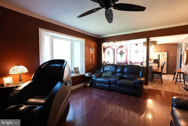 a living room with furniture floor to ceiling window and a flat screen tv