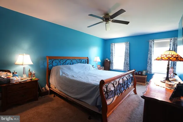 a bedroom with a bed a chandelier and a dresser