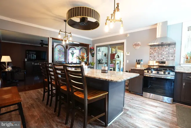 a kitchen with stainless steel appliances a dining table and chairs