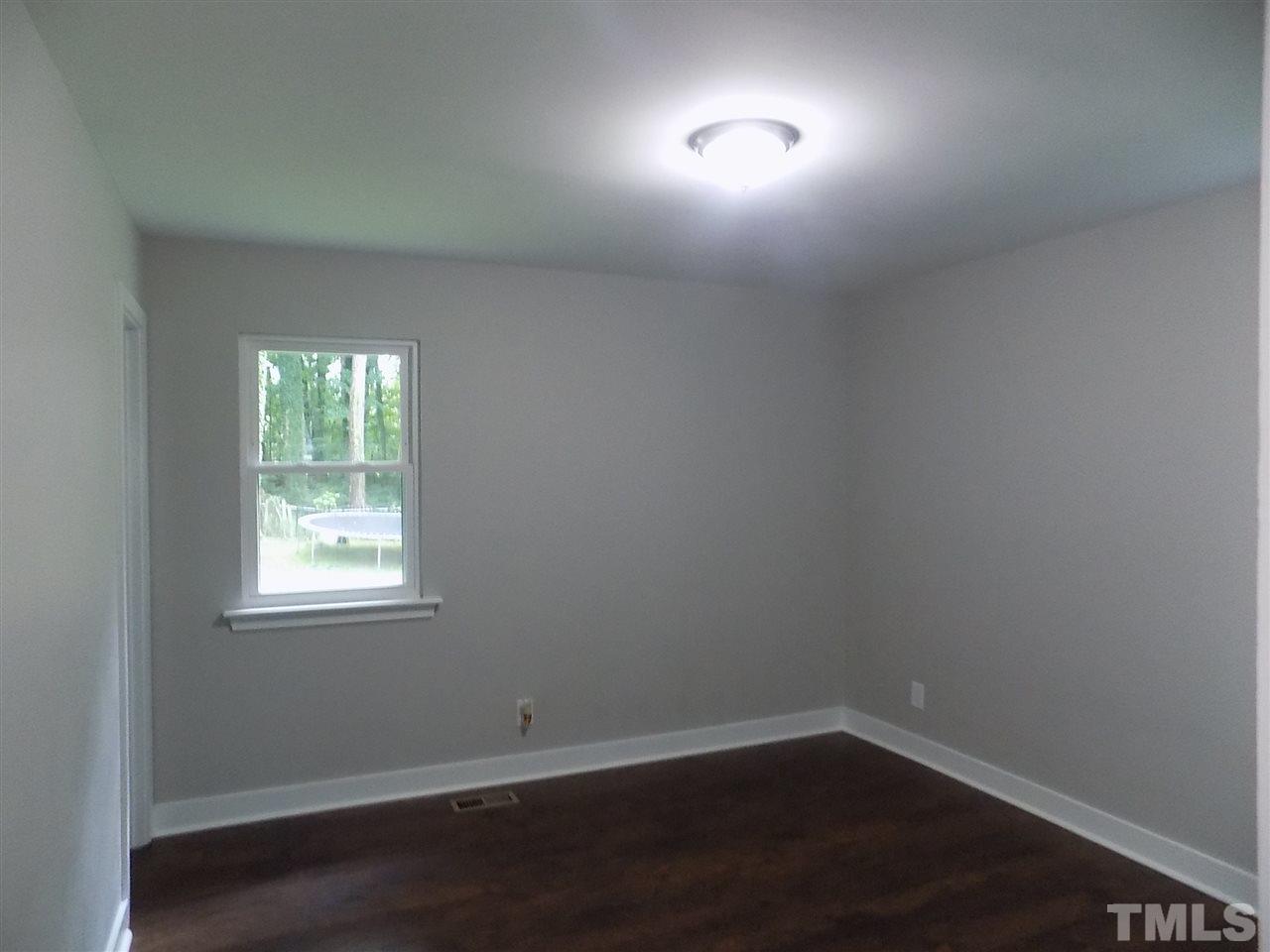 501 Lakeview Road Durham, NC 27712 - Photo 14 of 22 an empty room with wooden floor and windows