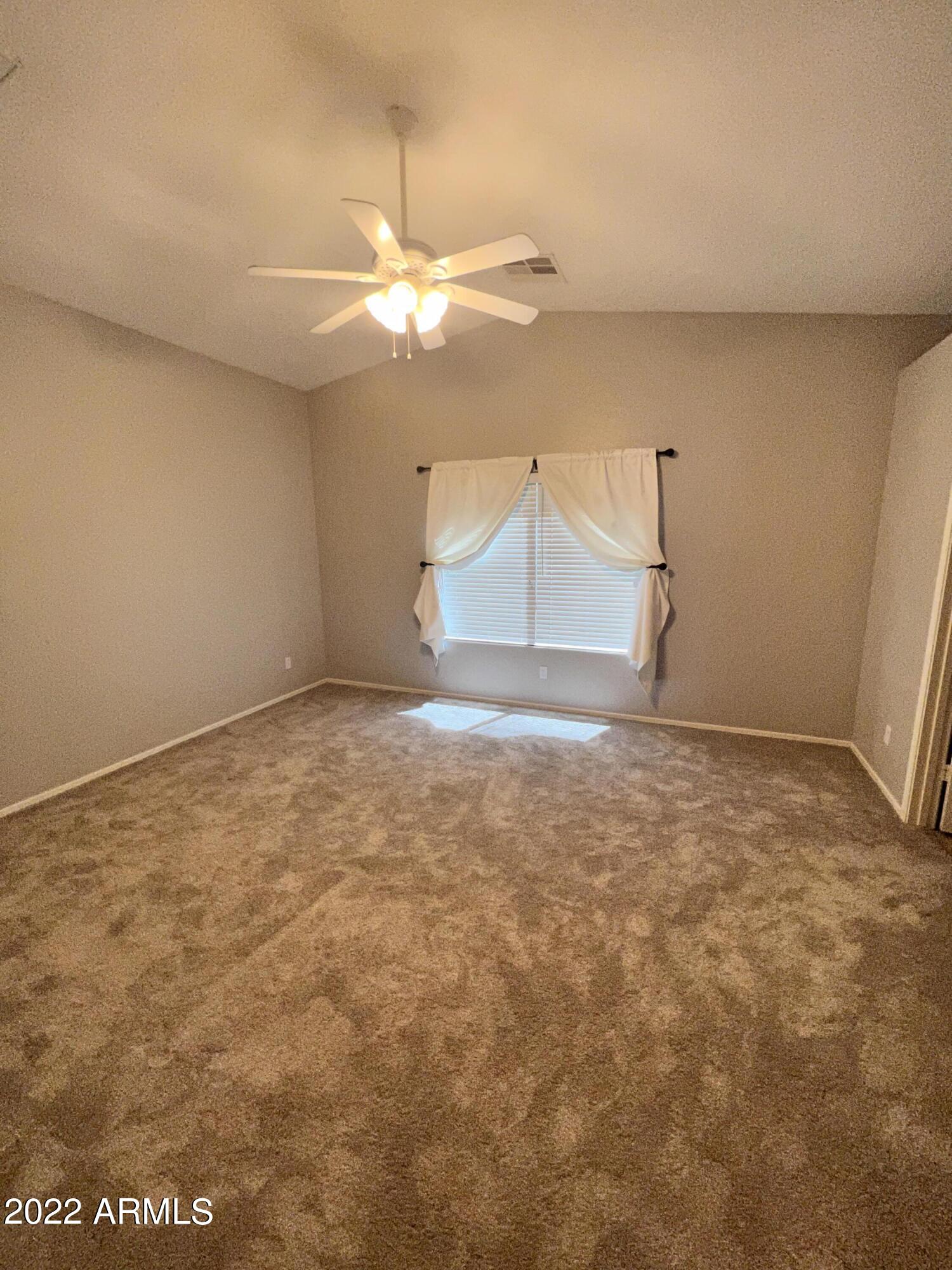 3797 East Ironhorse Road Gilbert, AZ 85297 - Photo 5 of 22 an empty room with a ceiling fan and carpet