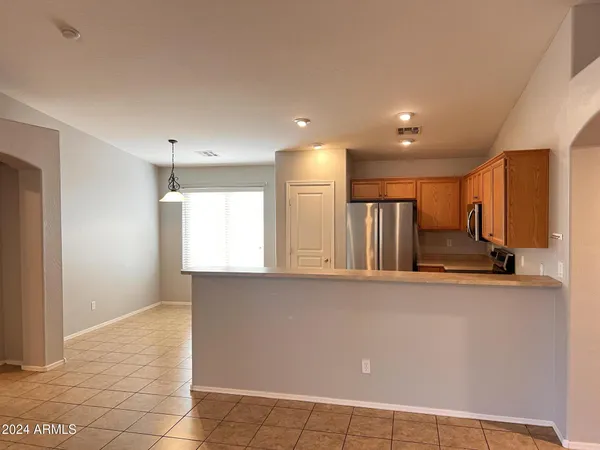 a view of a kitchen with stainless steel appliances a refrigerator and a stove top oven