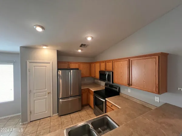 a kitchen with stainless steel appliances granite countertop a refrigerator and a stove