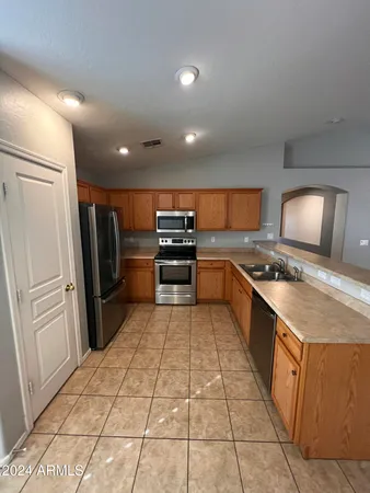 a large kitchen with a large counter top appliances and cabinets