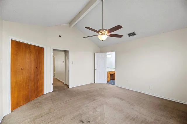 a view of a big room with carpet and a chandelier fan