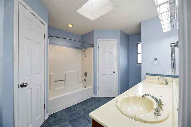 a spacious bathroom with a granite countertop sink a toilet a mirror and shower