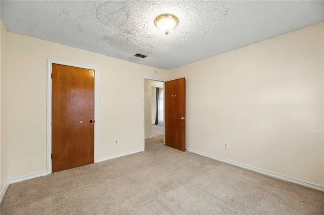 a backyard of a house with plants and large tree