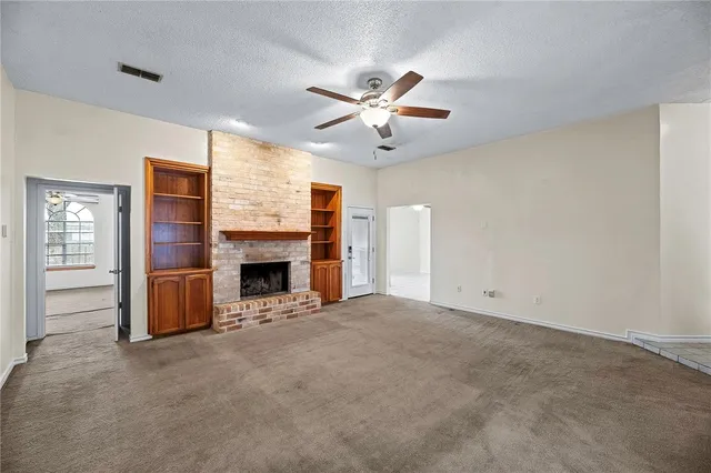 a view of a livingroom with a fireplace and window