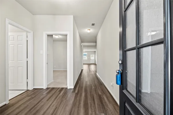 a view of a hallway with wooden floor and staircase