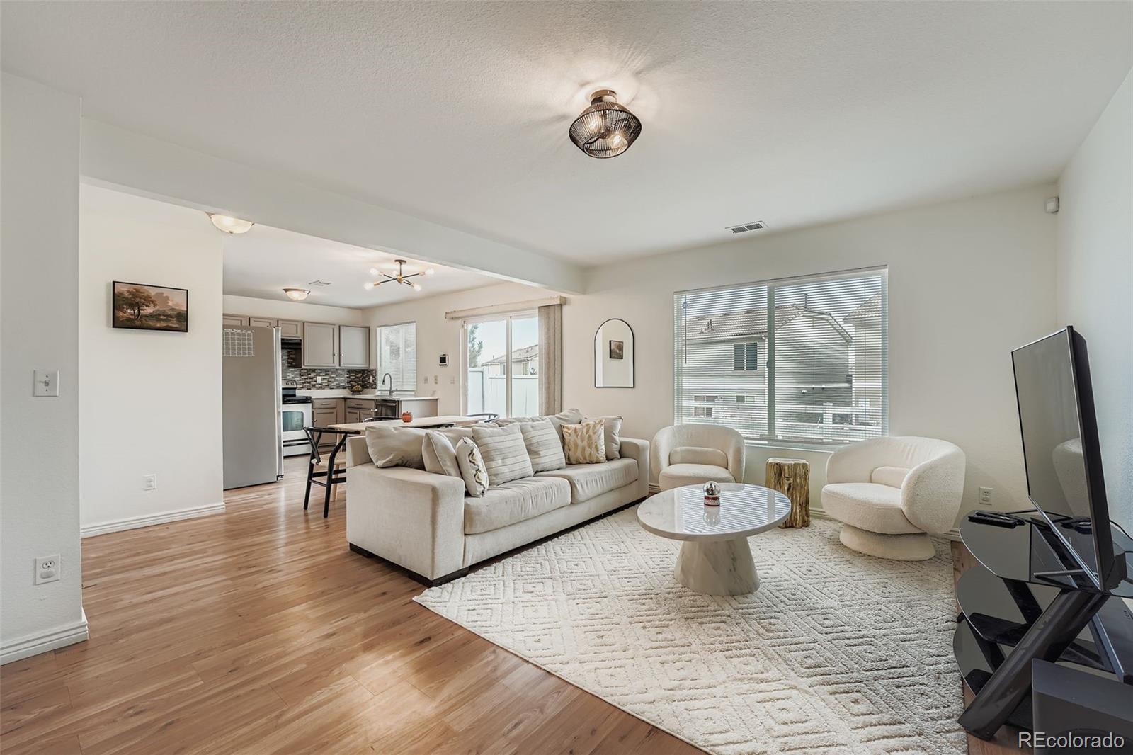 4250 Perth Circle Denver, CO 80249 - Photo 4 of 31 a living room with furniture a flat screen tv and a large window