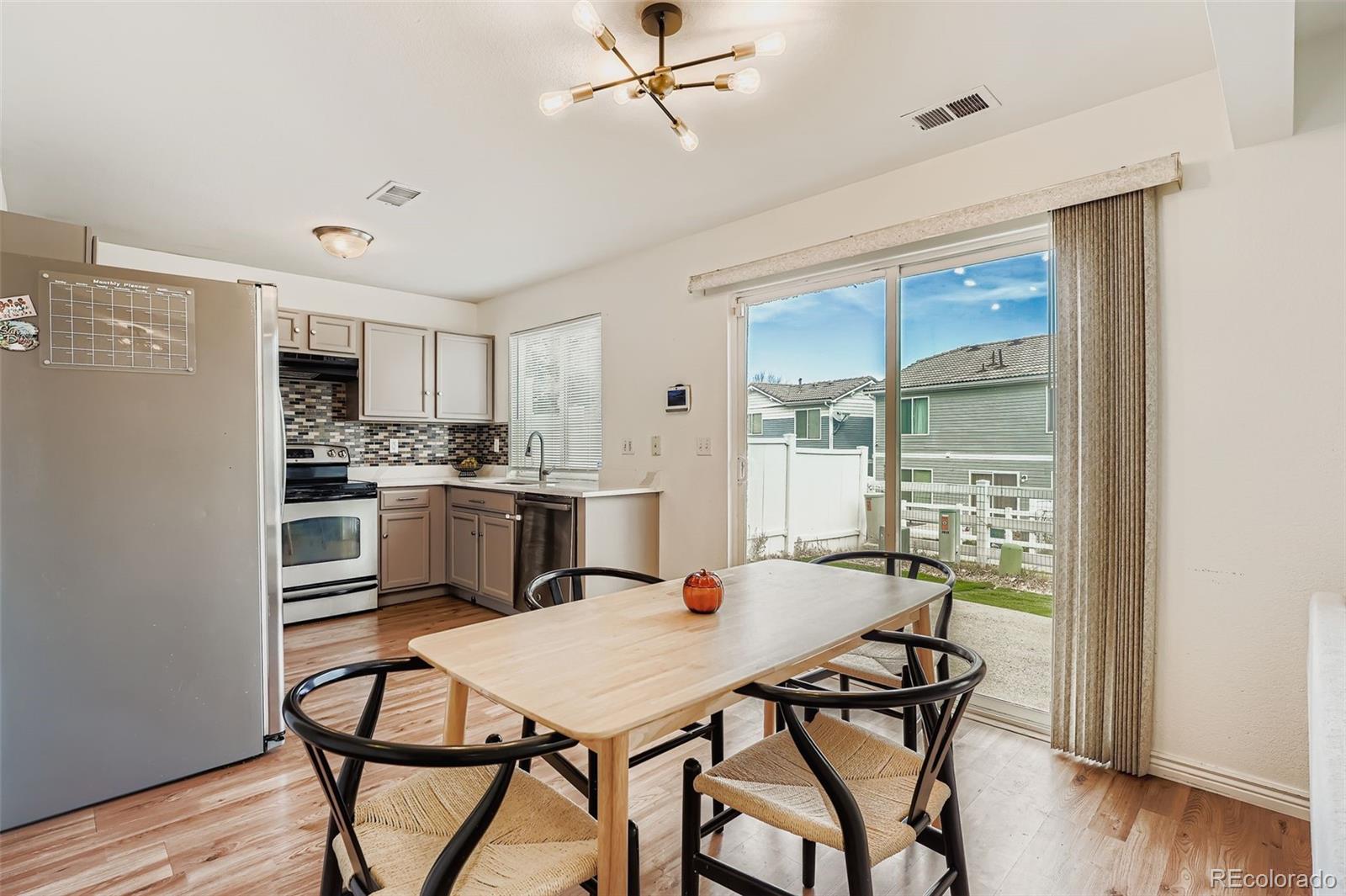 4250 Perth Circle Denver, CO 80249 - Photo 7 of 31 a kitchen with a table chairs refrigerator and cabinets