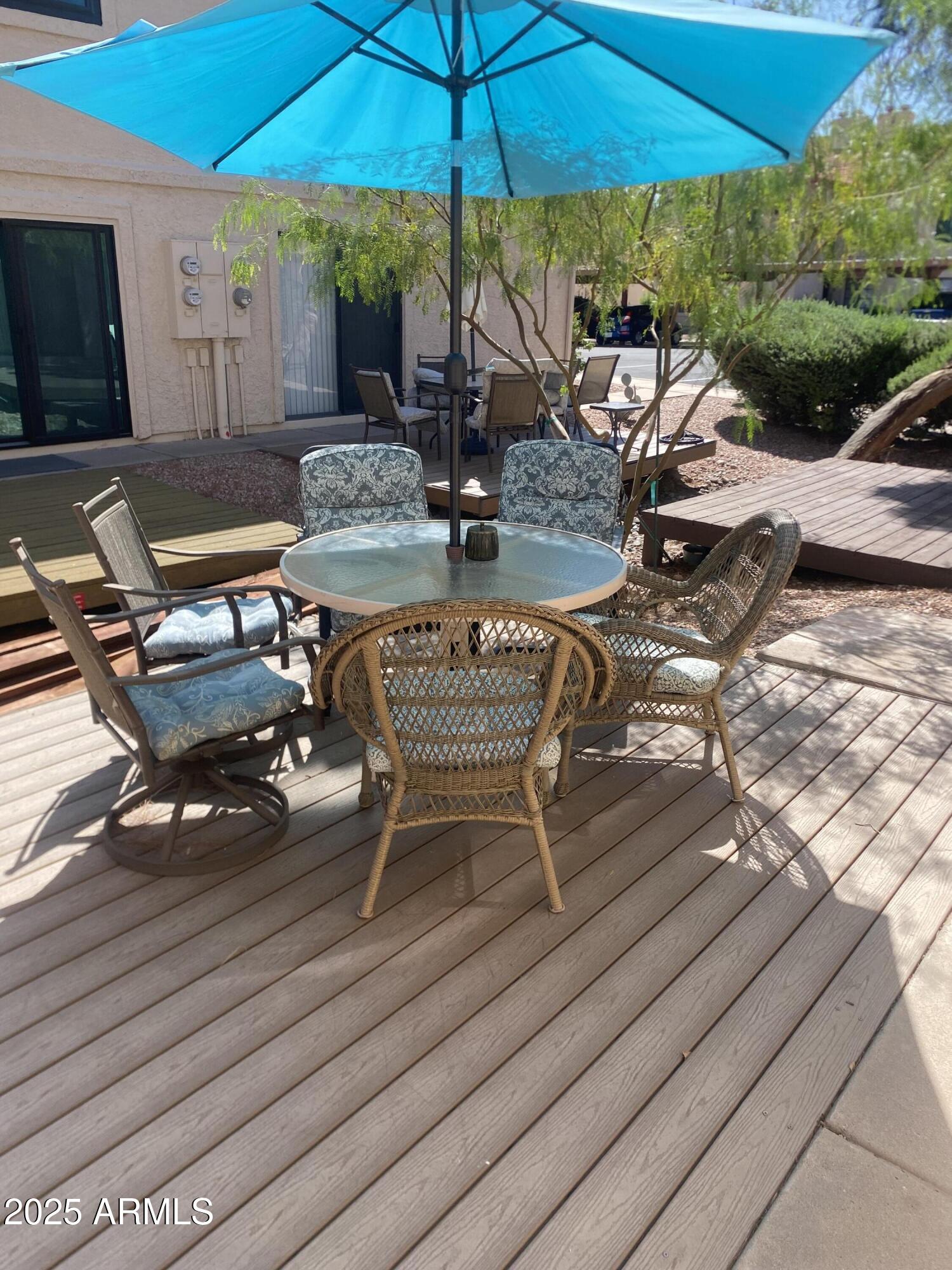 455 South Delaware Drive, Unit 171 Apache Junction, AZ 85120 - Photo 19 of 20 a view of a patio with chairs and table under an umbrella