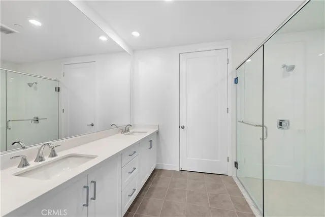 a spacious bathroom with a double vanity sink and mirror