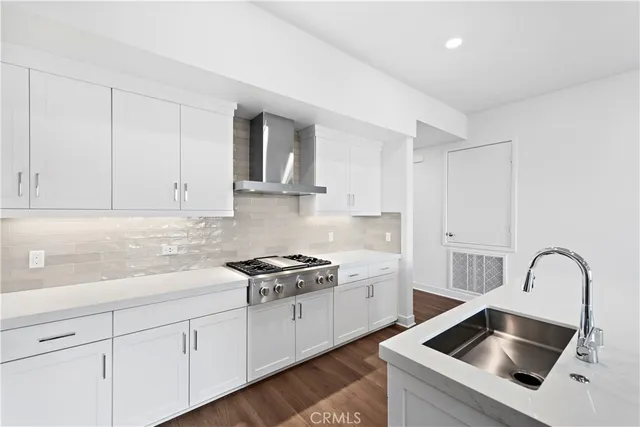 a kitchen with white cabinets a sink and dishwasher