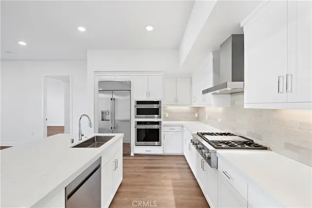 a kitchen with stainless steel appliances a sink stove and cabinets