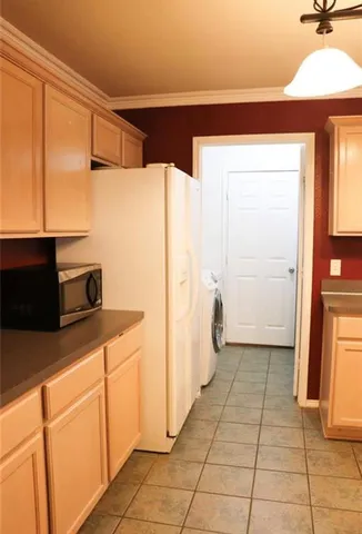 a kitchen with a refrigerator sink and cabinets