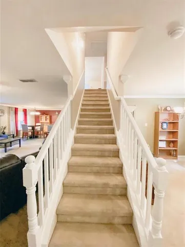 a view of staircase with lots of frames on wall and a view of entryway