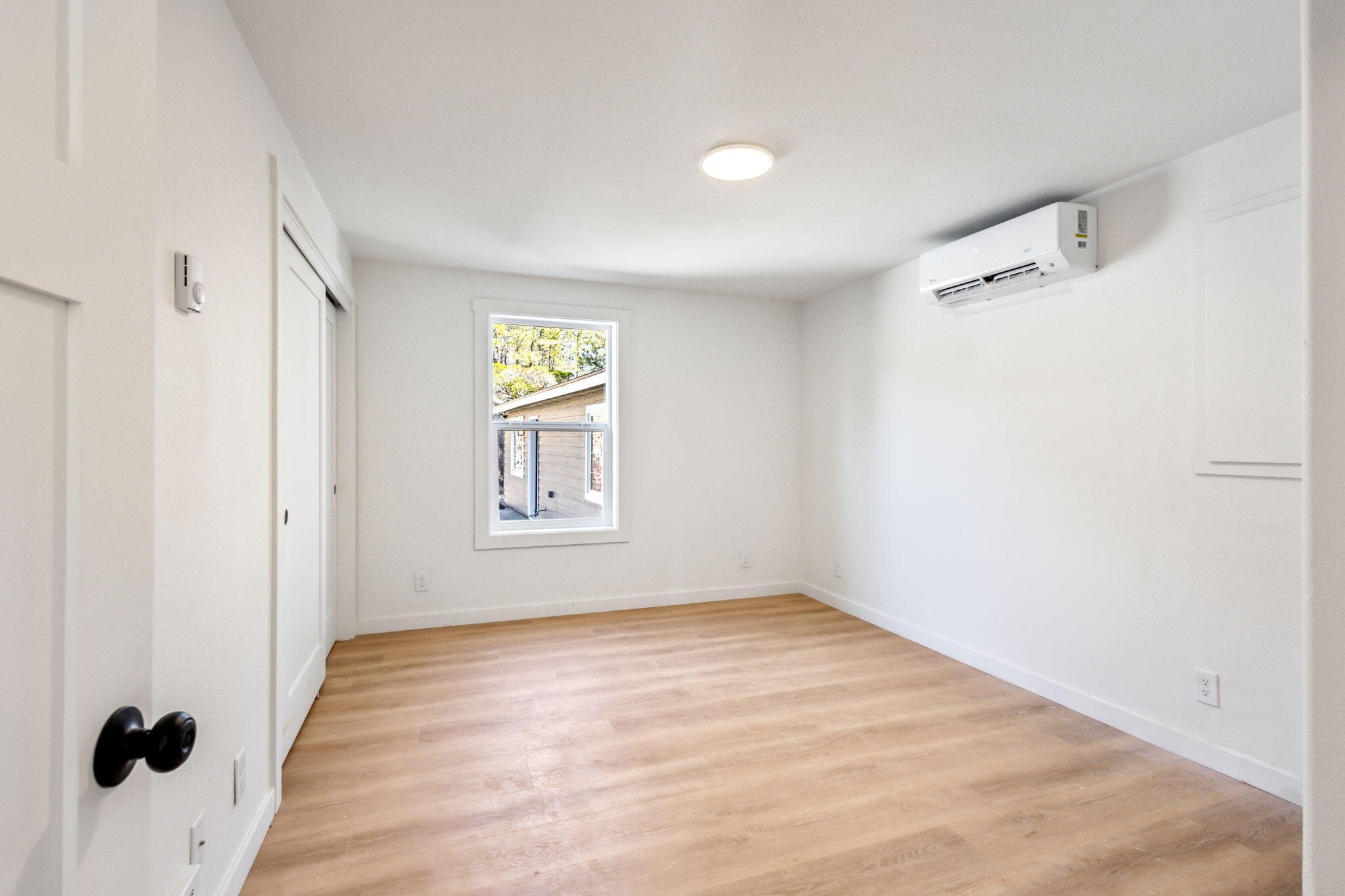 19126 Pumice Butte Road Bend, OR 97702 - Photo 17 of 40 a view of an empty room with wooden floor and a window