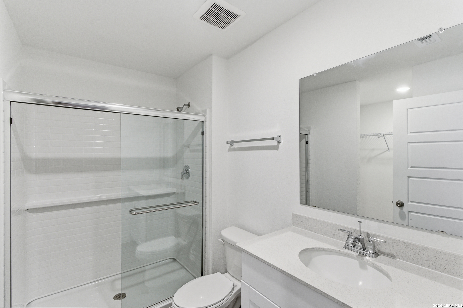 10107 Monte Carmel Place Adkins, TX 78101 - Photo 17 of 25 a bathroom with a shower sink vanity mirror and toilet