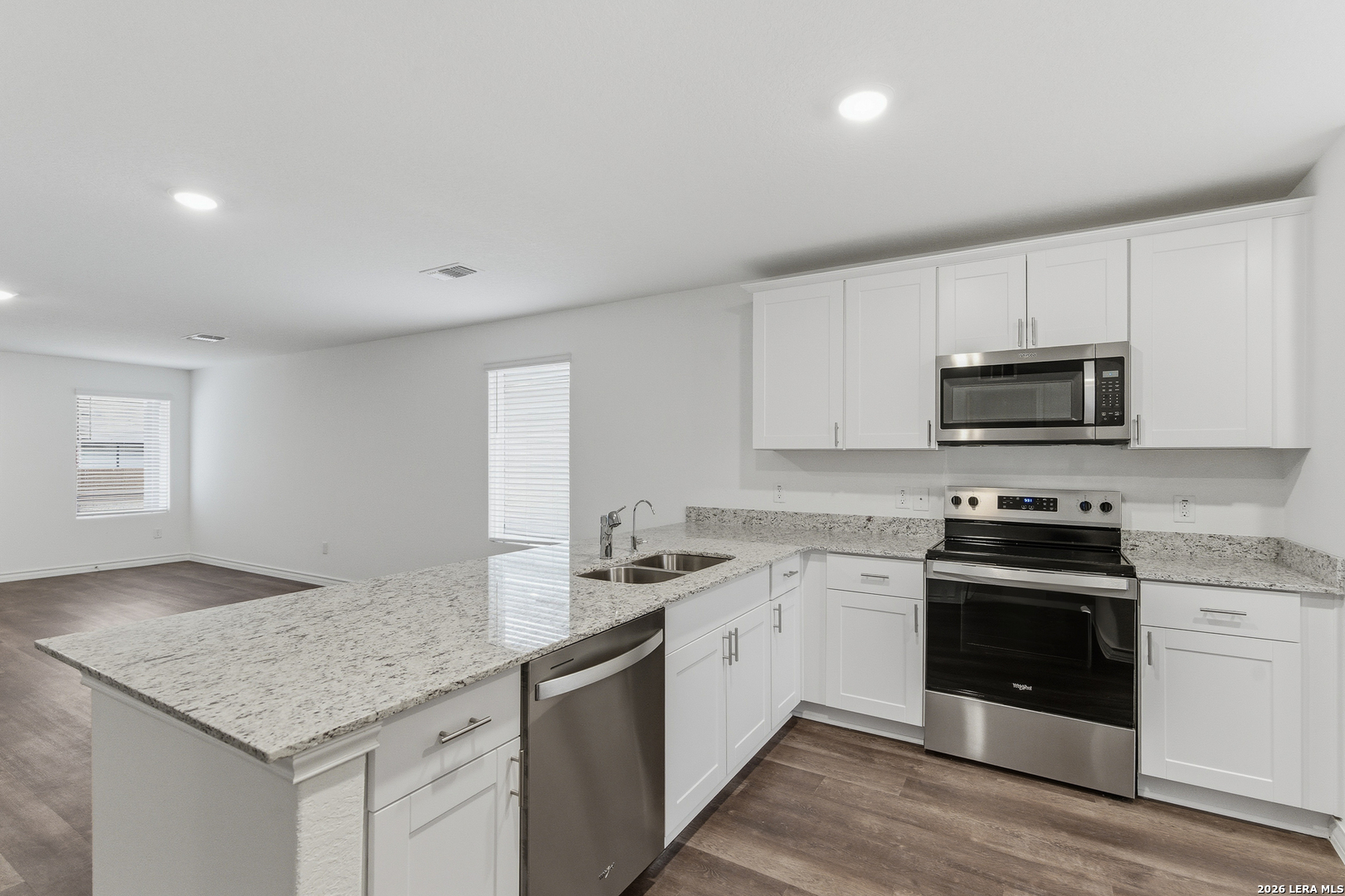 10107 Monte Carmel Place Adkins, TX 78101 - Photo 6 of 25 a kitchen with granite countertop stainless steel appliances a stove microwave and sink