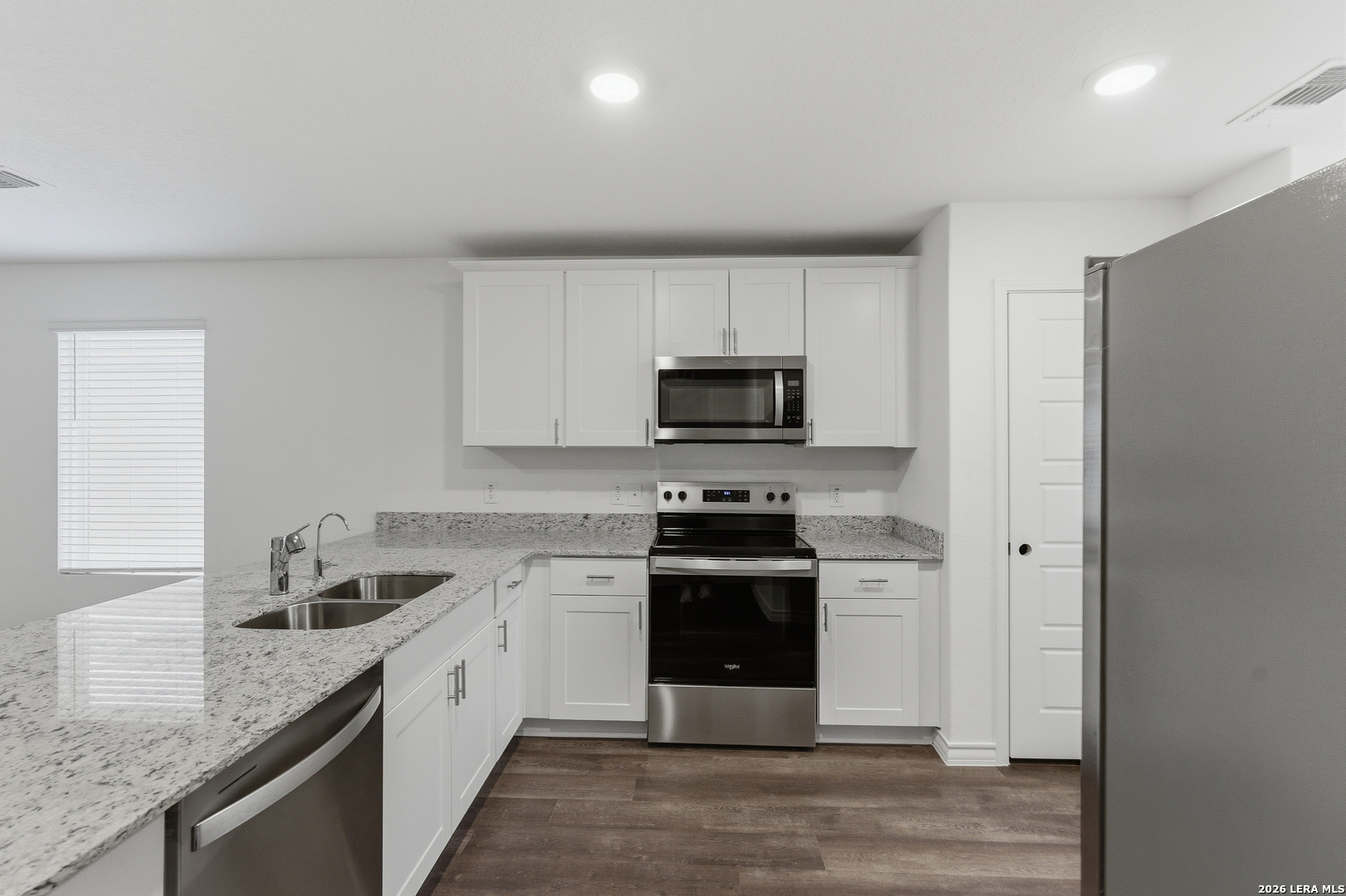 10107 Monte Carmel Place Adkins, TX 78101 - Photo 7 of 25 a kitchen with stainless steel appliances granite countertop a stove a sink and a microwave