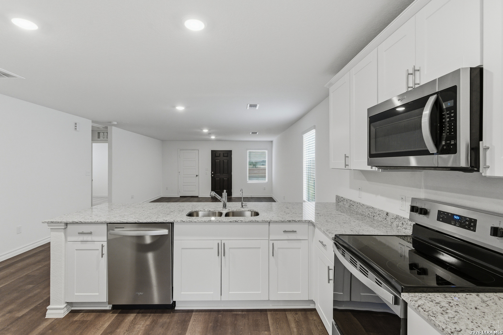 10107 Monte Carmel Place Adkins, TX 78101 - Photo 8 of 25 a kitchen with stainless steel appliances granite countertop a stove a microwave and cabinets