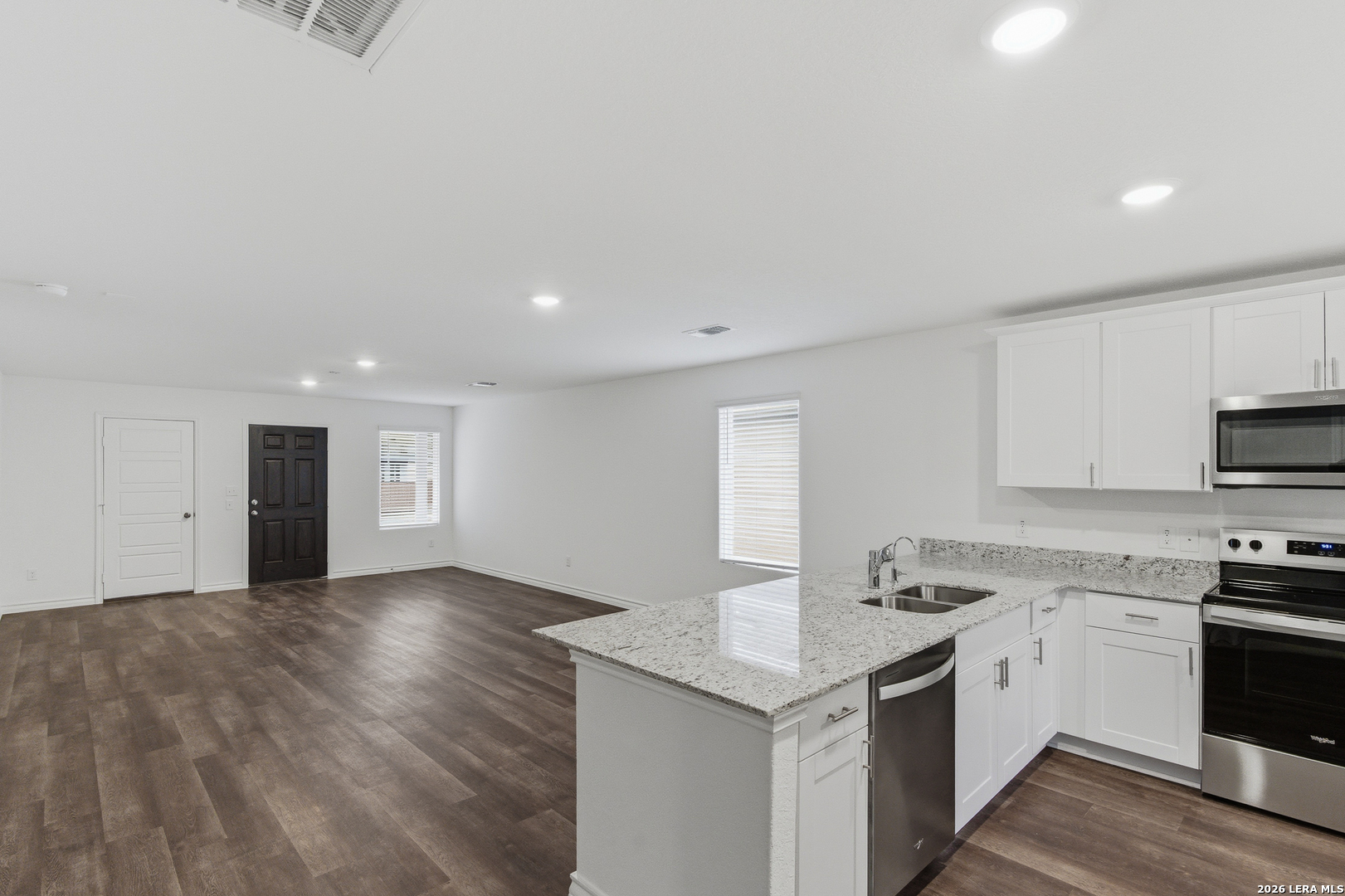 10107 Monte Carmel Place Adkins, TX 78101 - Photo 10 of 25 a kitchen with granite countertop white cabinets and white appliances