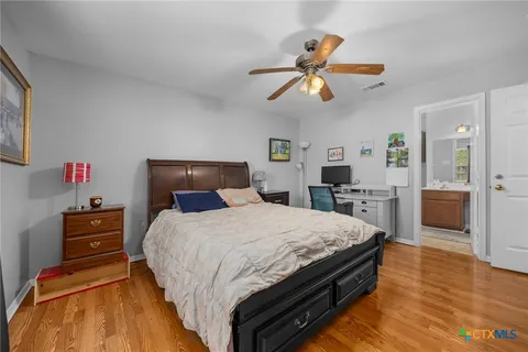 a bedroom with a bed and wooden floor