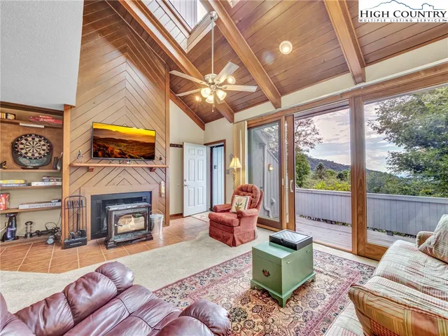 a living room with furniture a fireplace and a large window
