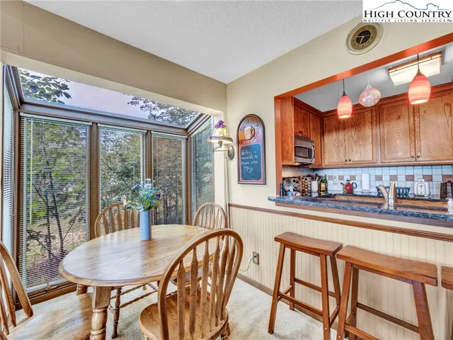 a dining room with furniture a rug and a large window