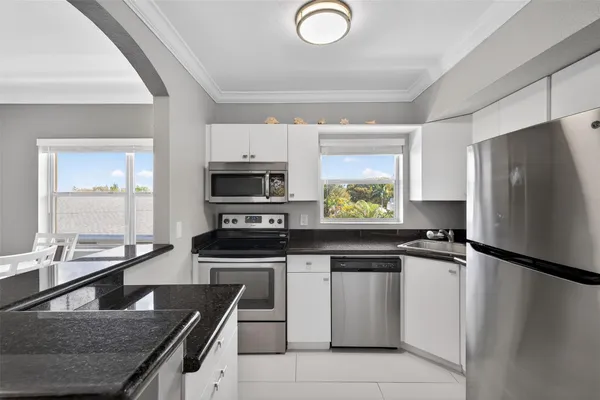 a kitchen with a refrigerator a stove a microwave and cabinets
