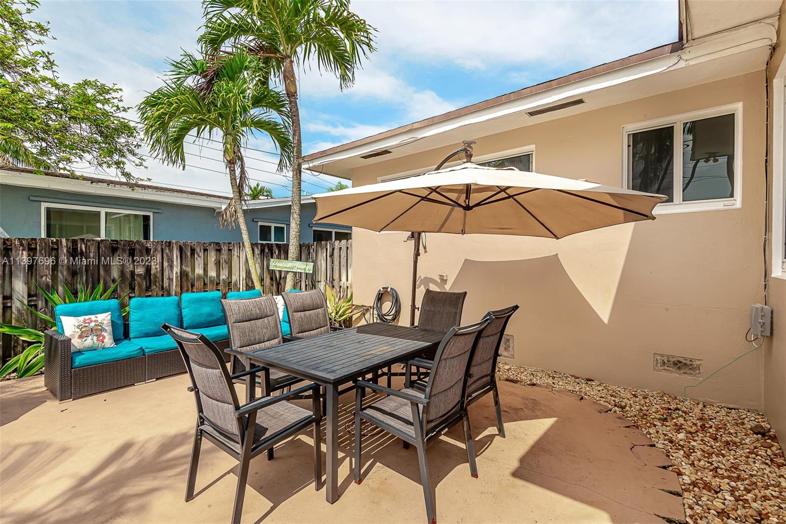 307 North Rainbow Drive Hollywood, FL 33021 - Photo 42 of 74 a patio with a table and chairs under an umbrella