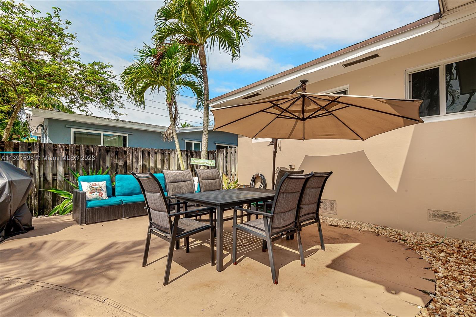 307 North Rainbow Drive Hollywood, FL 33021 - Photo 43 of 74 a patio with a table and chairs under an umbrella