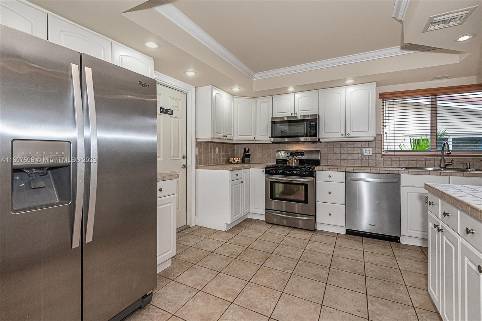 307 North Rainbow Drive Hollywood, FL 33021 - Photo 45 of 74 a kitchen with white cabinets stainless steel appliances and a sink