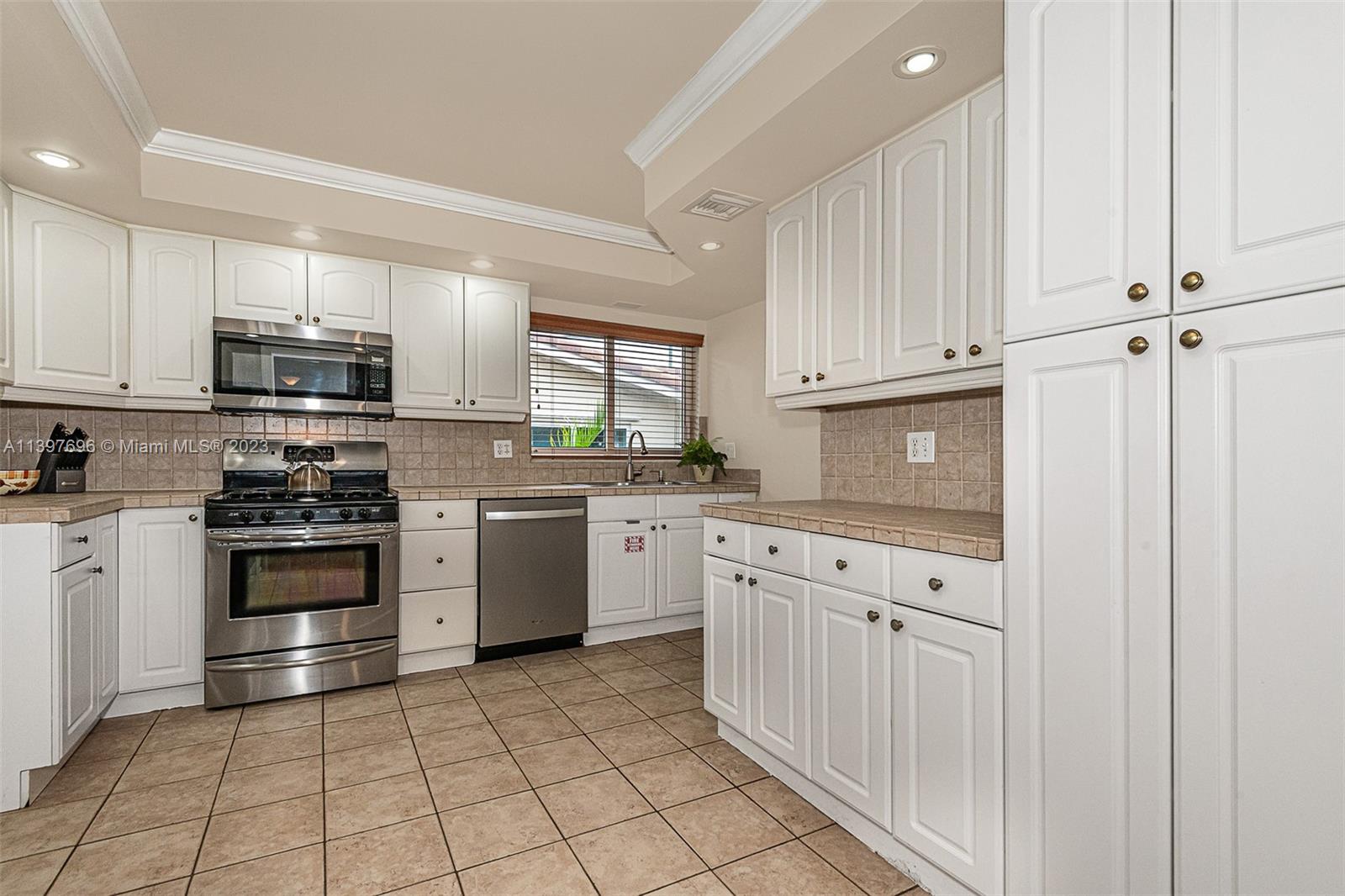 307 North Rainbow Drive Hollywood, FL 33021 - Photo 47 of 74 a kitchen with granite countertop white cabinets and stainless steel appliances
