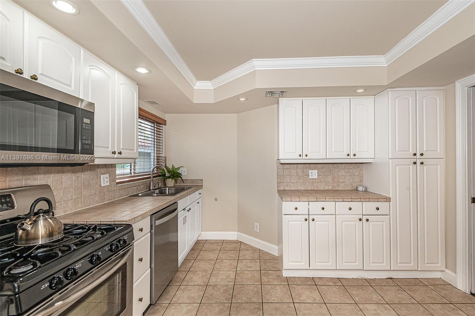 307 North Rainbow Drive Hollywood, FL 33021 - Photo 49 of 74 a kitchen with white cabinets and appliances