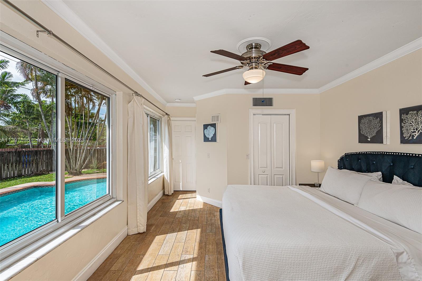 307 North Rainbow Drive Hollywood, FL 33021 - Photo 53 of 74 a bedroom with a large bed and a chandelier