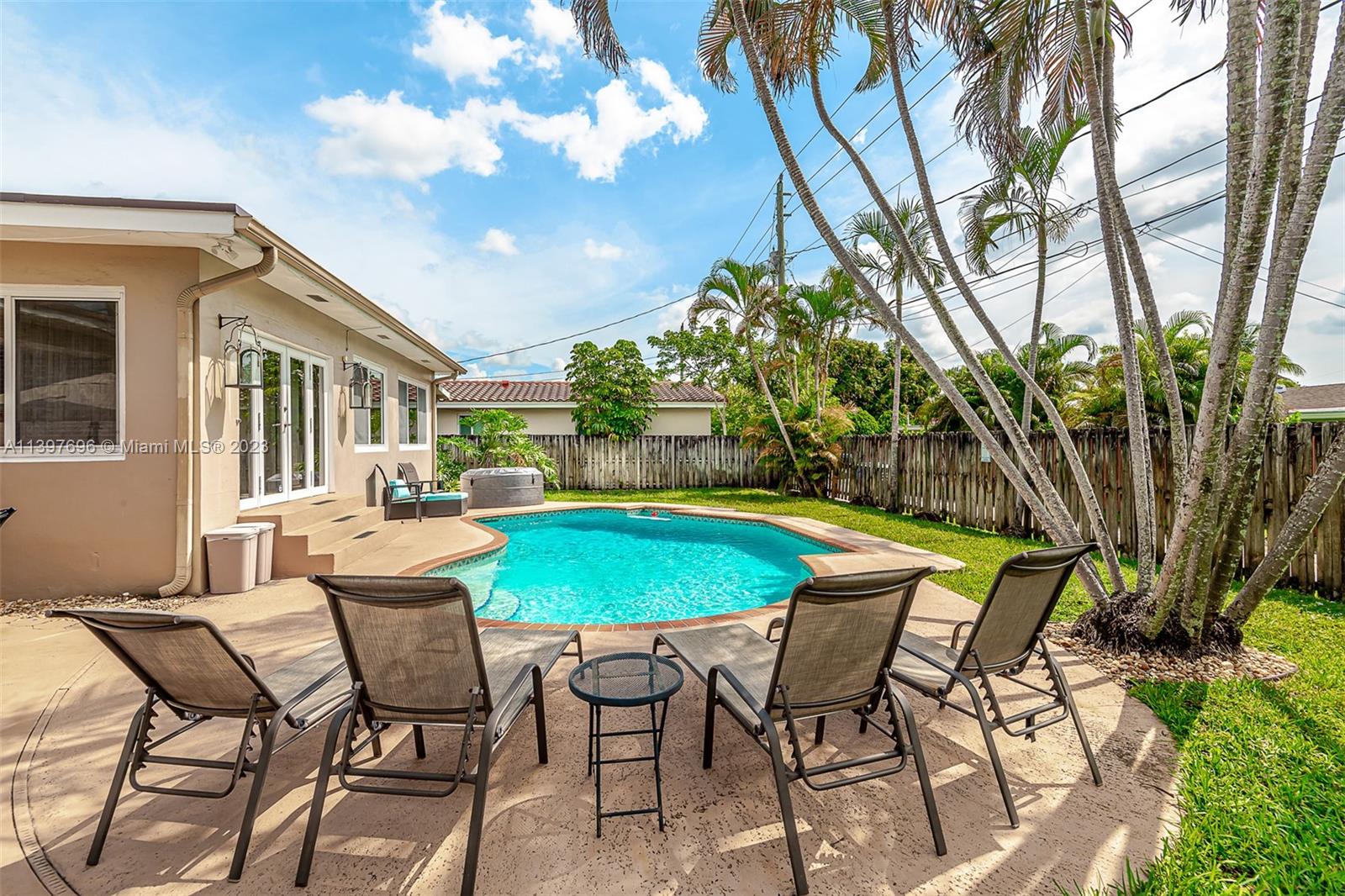 307 North Rainbow Drive Hollywood, FL 33021 - Photo 8 of 74 a patio with a yard table and chairs