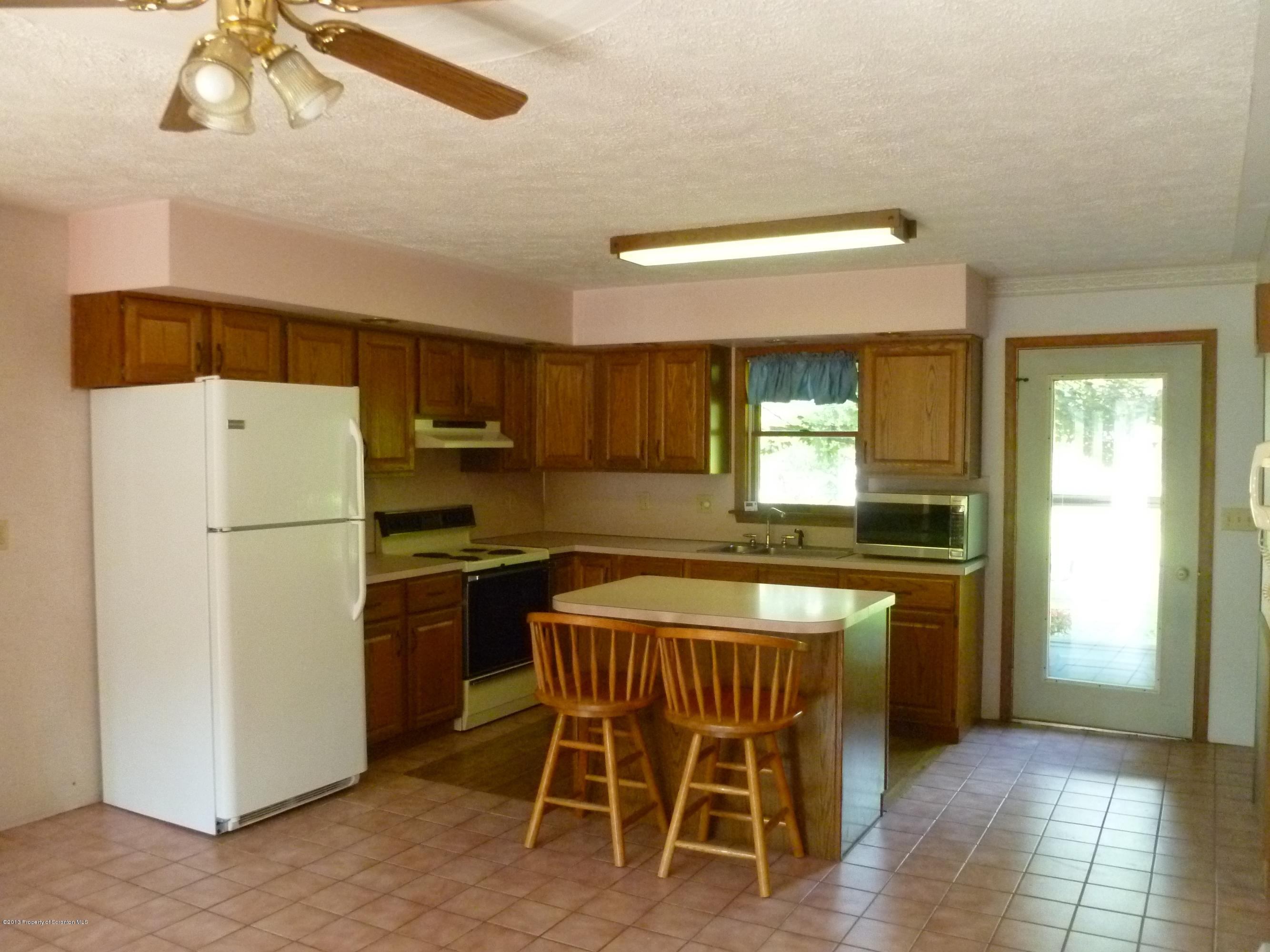 1250 Aberdeen Road Moscow, PA 18444 - Photo 3 of 32 a kitchen with a table chairs refrigerator and cabinets