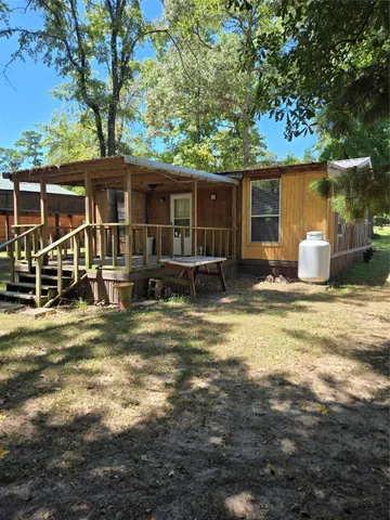 a view of house with backyard and trees