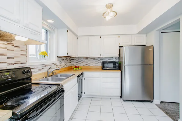 a kitchen with a refrigerator and a stove top oven