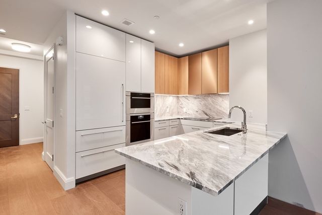 a kitchen with granite countertop white cabinets and stainless steel appliances